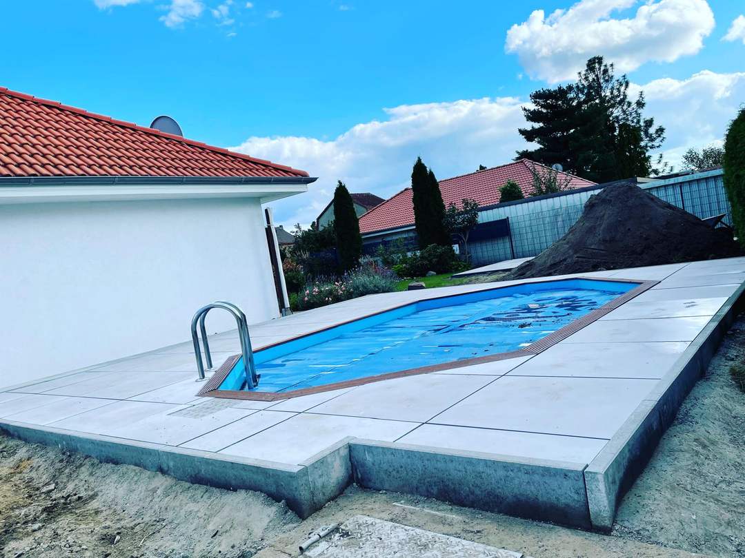 Fertiger Gartenpool mit Beckenrandstein und umliegendem Rasen