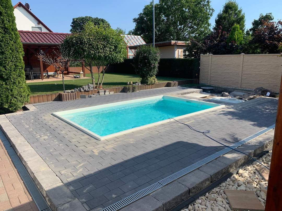 Fertig angelegter Pool mit Terrasse am Einfamilienhaus